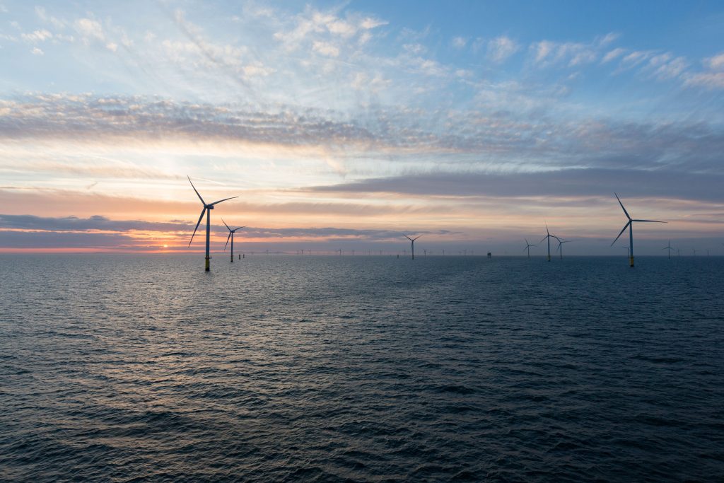 A photo of an offshore wind farm in sunset