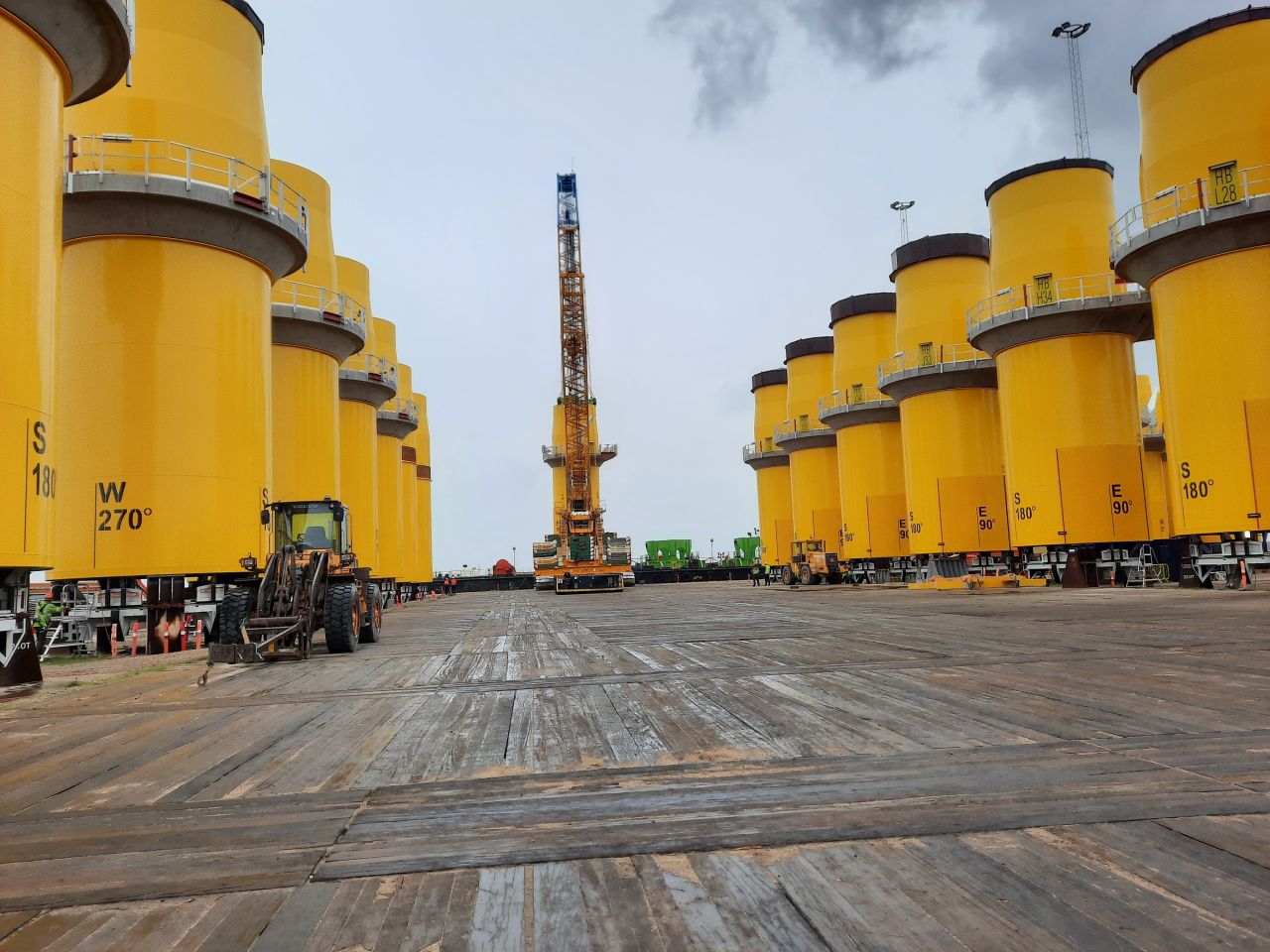 Yellow transition pieces upended and lined up at Bladt site in Aalborg