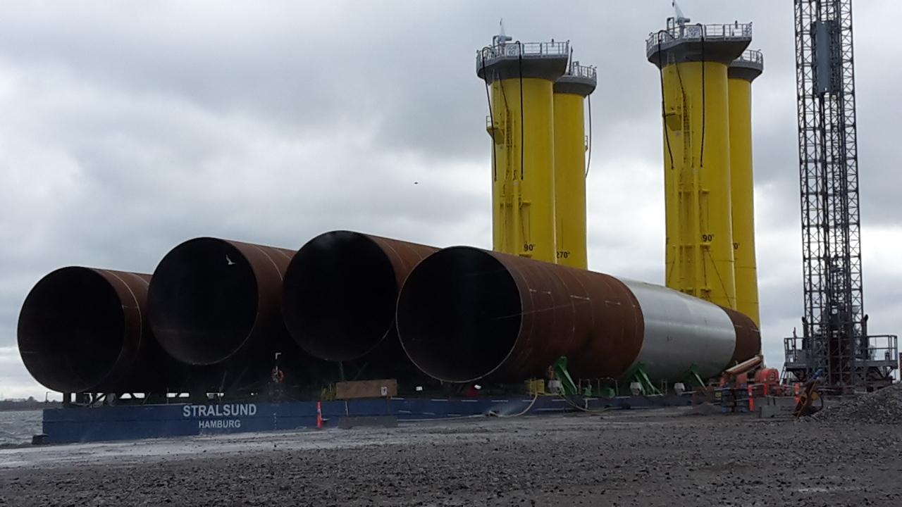 Monopiles and transition pieces being loaded at Bladt site