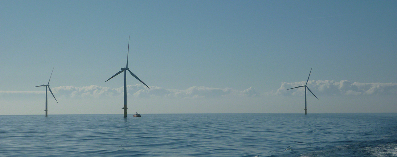 A photo of an offshore wind farm with a crew transfer vessel at the site