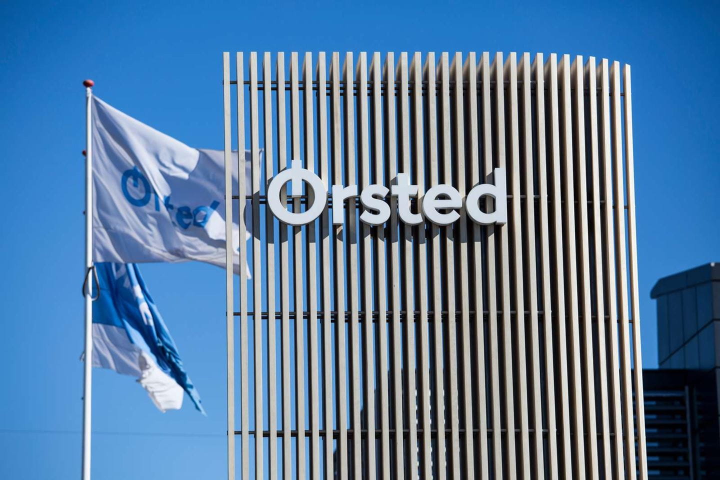 A photo of Orsted's headquarters with company logo and flags