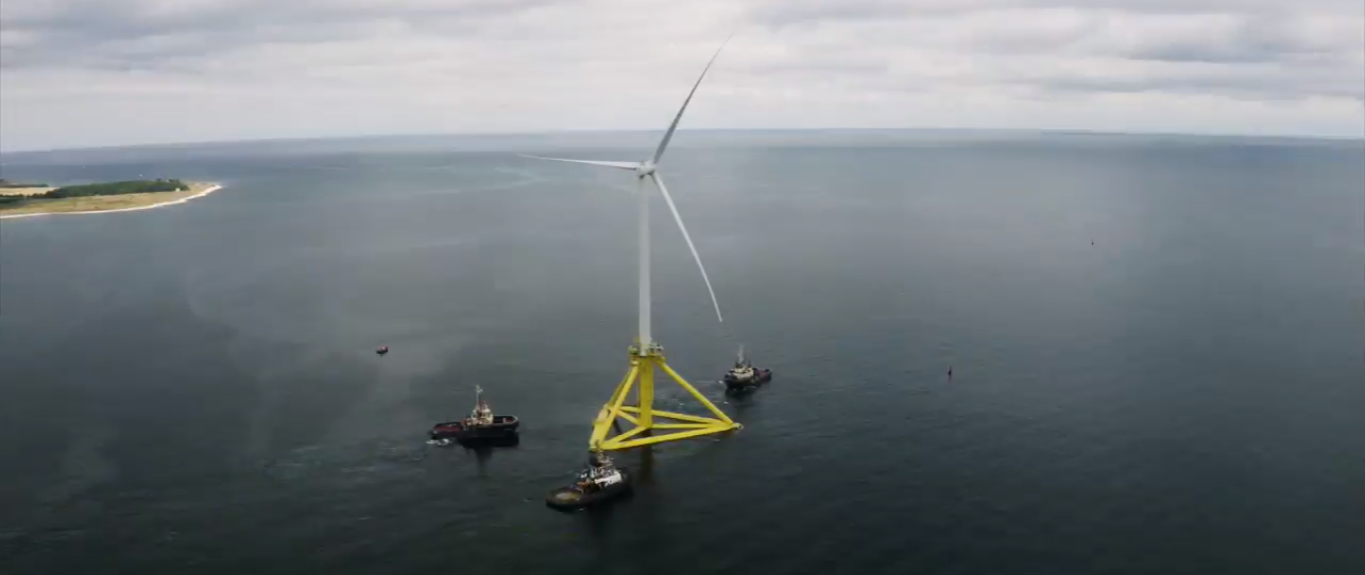 A screenshot of a video showing TetraSpar floater being towed out of Port of Greena